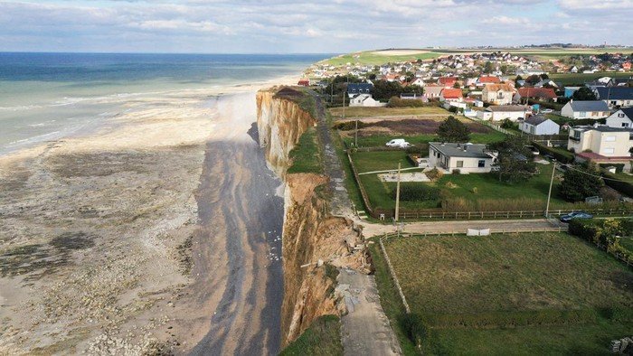 Penampakan Jalanan di Pantai Prancis Runtuh Tergerus Erosi A view shows a road and houses near a part of cliff that crashed into the sea due to coastal erosion in Criel-sur-Mer, France, March 03, 2023. REUTERS/Pascal Rossignol