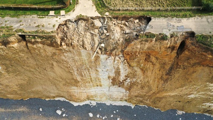 A view shows a road and houses near a part of cliff that crashed into the sea due to coastal erosion in Criel-sur-Mer, France, March 03, 2023. REUTERS/Pascal Rossignol
