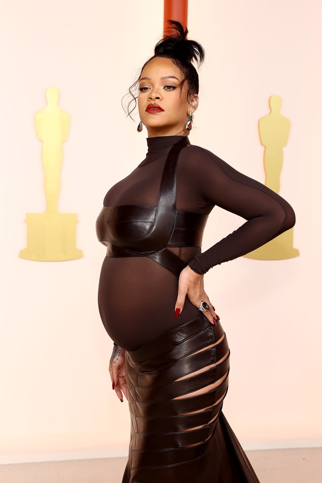 Oscars 2023 menjadi yang perdana bagi Rihanna setelah dinominasikan di kategori soundtrack terbaik berkat lagunya untuk film Wakanda Forever. Walau sedang mengandung, Rihanna yang juga tampil di panggung Oscars tetap sukses memberikan gaya totalnya dengan gaun Alaia. Bahan transparan gaun lantas dimanfaatkan Rihanna juga untuk memamerkan perut hamilnya yang mulai membesar. (Foto: Getty Images/Arturo Holmes)