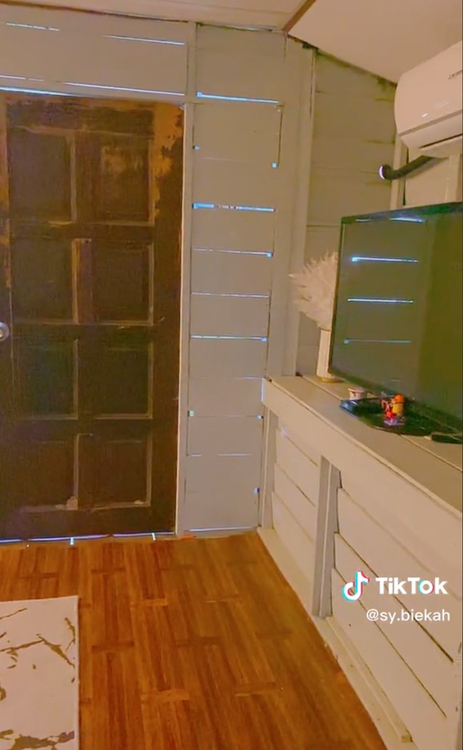 Lantainya pun jadi terlihat mewah dengan dilapisi vinyl kayu dan karpet. Ditambah dengan sofa, meja kaca, lemari, televisi, cermin, dan beberapa tanaman hias, rumah tersebut jadi tampak jauh berbeda dengan yang sebelumnya. Foto: TikTok/@sy.biekah
