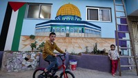Tampak dua anak bermain di dinding yang dilukis Masjid Al Aqsa.  