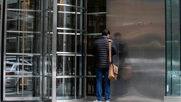 Seorang pekerja tiba di kantor pusat Signature Bank di New York City, AS. (REUTERS/EDUARDO MUNOZ)