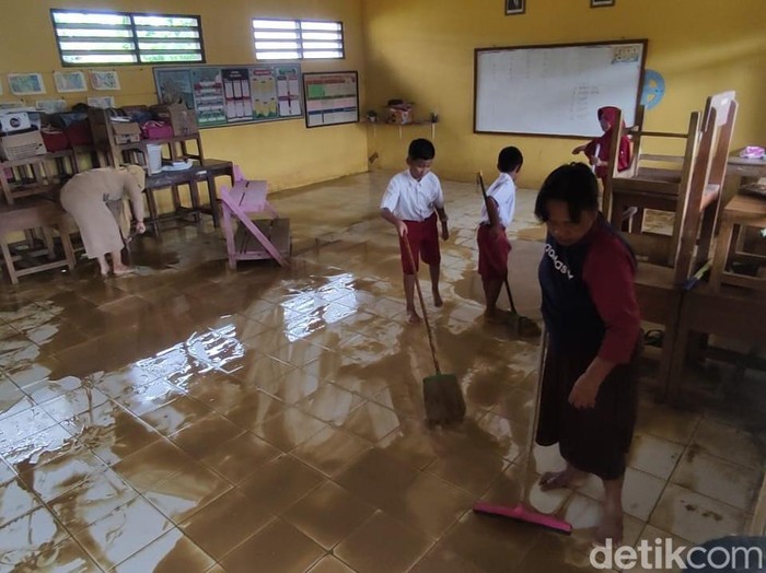 Siswa SDN 2 Banjarsari, Kecamatan Gabus, Pati membersihkan ruang kelas usai banjir surut, Senin (13/3/2023).