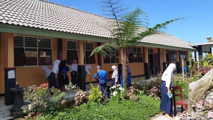 Siswa SMP 2 Dukun, Kabupaten Magelang melakukan pembersihan abu di lingkungan sekolah, Senin (13/3/2023).