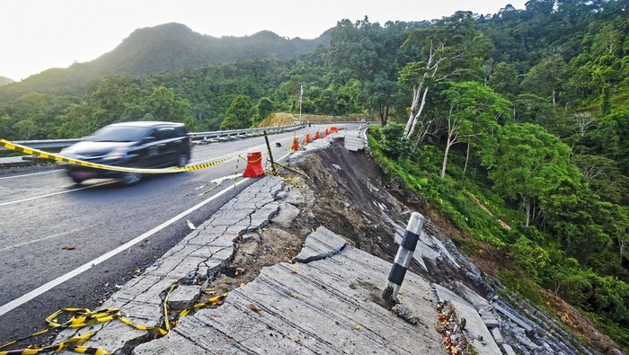 TEBING LONGSOR DI JALUR WISATA PUSUK LOMBOK Kendaraan melintas di dekat tebing yang longsor di jalur wisata Pusuk, Kecamatan Pemenang, Tanjung, Lombok Utara, NTB, Senin (13/3/2023). Longsor yang terjadi akibat hujan lebat tersebut menyebabkan jalan wisata Pusuk yang menghubungkan Kabupaten Lombok Barat dengan Kabupaten Lombok Utara amblas sepanjang sekitar 25 meter dengan kedalaman sekitar 15 meter.ANTARA FOTO/Ahmad Subaidi/aww.