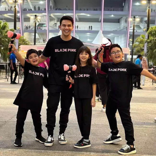 Ketiga anak Jonathan Frizzy tampak ikut menghadiri konser BLACKPINK ditemani sang ayah. Terlihat Jonathan Frizzy bersama ketiga anaknya itu kompak tampil simpel mengenakan kaos dan celana panjang hitam. Terdapat tulisan BLACKPINK warna merah muda pada bagian kaosnya. Foto: Instagram