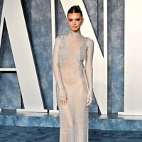 Emily Ratajkowski memperlihatkan lekuk tubuhnya yang ramping dalam balutan gaun transparan dari koleksi Feben. Busananya memiliki detail unik berupa tali yang dirangkai di sepanjang bahu hingga tulang rusuk. Foto: Getty Images