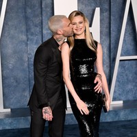 Berpose di hadapan puluhan fotografer, mereka tak ragu untuk tampil mesra. Tampak Adam merangkul Behati. (Foto: Doug Peters/PA Images via Getty Images)