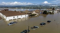 Banjir menggenangi rumah dan kendaraan di komunitas Pajaro di Monterey County. Para petugas di layanan cuaca memperingatkan potensi terjadinya “banjir yang cukup besar” akibat hujan lebat dan mencairnya salju yang dapat membuat sejumlah sungai dan anak sungai meluap. AP/Noah Berger  