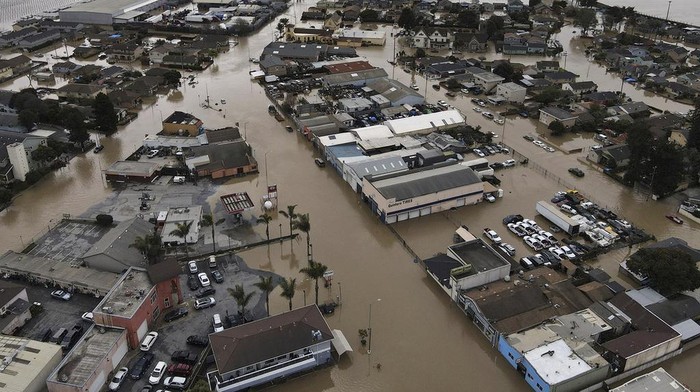 Foto Udara Banjir California Imbas Cuaca Buruk-Tanggul Jebol This aerial photo shows the majority of the north Monterey County town of Pajaro, Calif., just across the Pajaro River from Watsonville, Calif., submerged with floodwaters on Sunday, March 12, 2023. Officials had been working to shore up parts of the river's levee system when it was breached around midnight Friday into Saturday. (Shmuel Thaler/The Santa Cruz Sentinel via AP)
