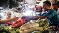 Seorang pedagang sayuran melayani pembeli di kawasan Pasar Koja Baru, Koja, Jakarta Utara, Selasa (14/3/2023).  