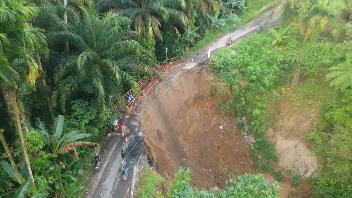 Jalan Longsor, Jalur Padang Pariaman-Agam Dibangun Jembatan Darurat Foto udara warga melewati jembatan darurat yang baru dibangun akibat jalan longsor, di Nagari Gunung Padang Alai, Kabupaten Padang Pariaman, Sumatera Barat, Selasa (14/3/2023). Jalan penghubung Kota Pariaman dengan Kabupaten Padang Pariaman dan Kabupaten Agam tersebut longsor akibat curah hujan tinggi dan warga membuat jembatan darurat untuk kendaraan roda dua serta pejalan kaki.