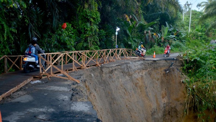 Jalan Longsor, Jalur Padang Pariaman-Agam Dibangun Jembatan Darurat Foto udara warga melewati jembatan darurat yang baru dibangun akibat jalan longsor, di Nagari Gunung Padang Alai, Kabupaten Padang Pariaman, Sumatera Barat, Selasa (14/3/2023). Jalan penghubung Kota Pariaman dengan Kabupaten Padang Pariaman dan Kabupaten Agam tersebut longsor akibat curah hujan tinggi dan warga membuat jembatan darurat untuk kendaraan roda dua serta pejalan kaki.
