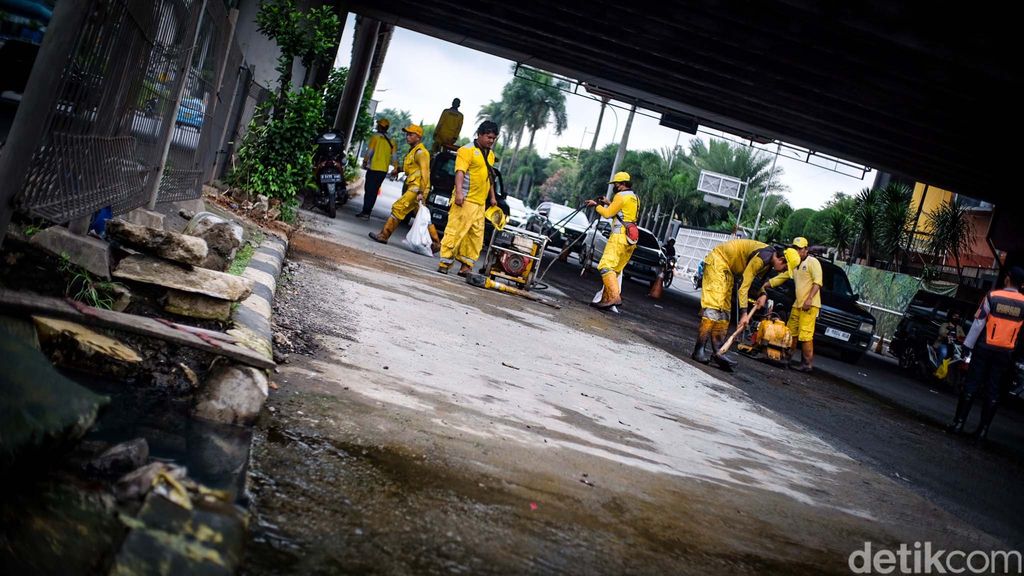 Petugas Bina Marga DKI Jakarta mulai memperbaiki rusak di depan Pondok Indah Mall (PIM), Jakarta, Selasa (14/3/2023). Jalan rusak tengah ditambal petugas.
