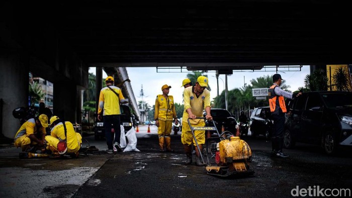 Petugas Bina Marga DKI Jakarta mulai memperbaiki rusak di depan Pondok Indah Mall (PIM), Jakarta, Selasa (14/3/2023). Jalan rusak tengah ditambal petugas.
