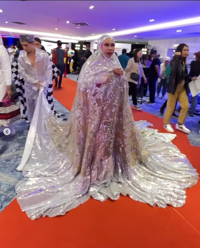 Dalam unggahannya yang lain, Datuk Seri Vida mengatakan busana yang dipakainya ke acara penghargaan ini diberi nama telekung dress. Ia menjelaskan jika telekung dress atau baju mukena tersebut dibuat oleh Behati, perancang asal Malaysia. Datuk Seri berkelakar mukena jumbo itu akan menutupi berapa shaf jika mau salat tarawih. Foto: Dok. Instagram @kel__wen.