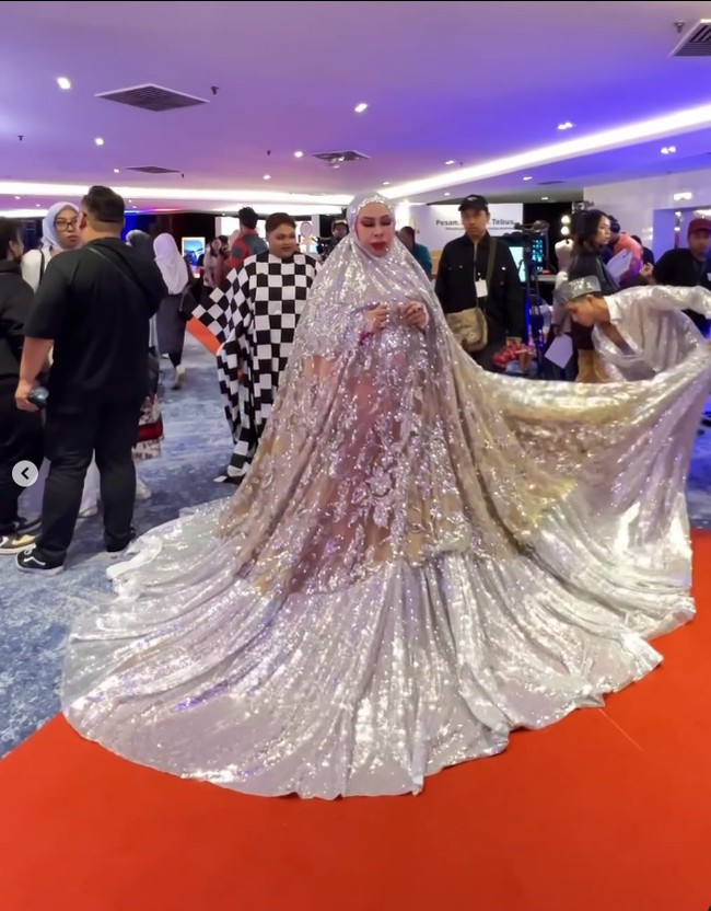 Unggahan wanita yang berusia 51 tahun itu sudah ditonton lebih dari 12,5 juta Views dan mendapatkan beragam komentar dari warganet. Ada yang kaget dan heran melihat ukuran mukena yang terlalu besar. Sebagian lagi menudingnya telah melecehkan agama Islam karena memakai mukena yang merupakan alat salat ke acara selebriti. Foto: Dok. Instagram @kel__wen.