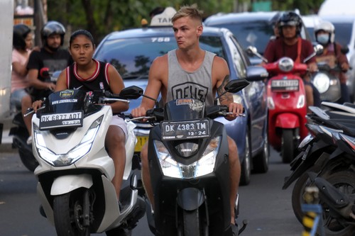 Turis asing mengendarai sepeda motor sewaan tanpa menggunakan helm di Jalan Pantai Kuta, Badung, Bali, Senin (13/3/2023). Gubernur Bali Wayan Koster mengimbau turis asing agar selalu mematuhi segala peraturan yang berlaku di Indonesia serta meminta menggunakan kendaraan yang disediakan oleh agen perjalanan dan tidak menggunakan kendaraan sendiri menyusul banyaknya turis asing yang ugal-ugalan mengendarai sepeda motor. ANTARA FOTO/Nyoman Hendra Wibowo/foc.