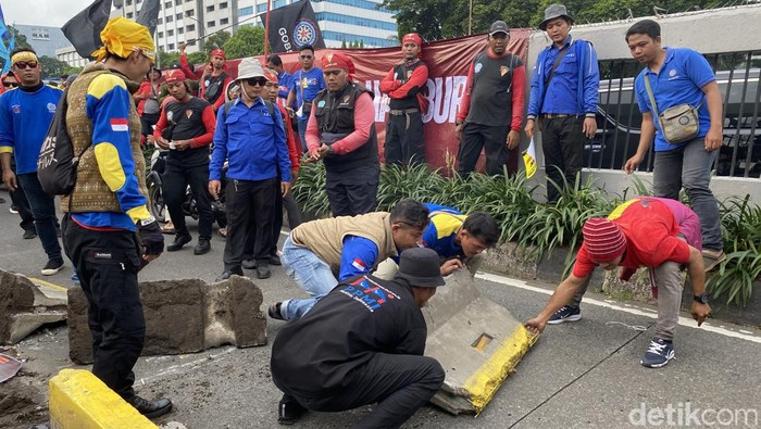 Massa demo di DPR bongkar beton pembatas lalu tutup jalur TransJakarta. (Devi/detikcom)