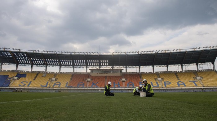 Pekerja merawat rumput lapangan sepak bola saat renovasi Stadion Si Jalak Harupat di Soreang, Kabupaten Bandung, Jawa Barat, Sabtu (11/3/2023). Renovasi Stadion Si Jalak Harupat tersebut ditujukan untuk perhelatan Piala Dunia U-20 pada Mei hingga Juni 2023 mendatang. ANTARA FOTO/M Agung Rajasa/nym.