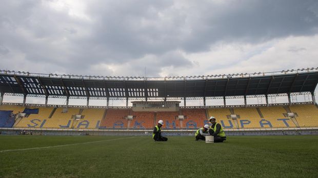 Pekerja merawat rumput lapangan sepak bola saat renovasi Stadion Si Jalak Harupat di Soreang, Kabupaten Bandung, Jawa Barat, Sabtu (11/3/2023). Renovasi Stadion Si Jalak Harupat tersebut ditujukan untuk perhelatan Piala Dunia U-20 pada Mei hingga Juni 2023 mendatang. ANTARA FOTO/M Agung Rajasa/nym.