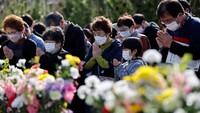 Orang-orang mengheningkan cipta memperingati 12 tahun gempa besar, tsunami dan bencana nuklir di Iwaki, Prefektur Fukushima, Jepang, Sabtu (11/3/2023). Mengheningkan cipta dilakukan secara nasional pada pukul 14:46, saat gempa terjadi. REUTERS/Issei Kato  