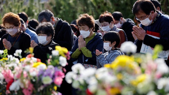 People observe a moment of silence at 2:46 p.m. (0546 GMT), the time when the magnitude 9.0 earthquake and tsunami struck off Japan's coast that killed thousands and triggering the worst nuclear accident since Chernobyl, during its 12-year anniversary, in Iwaki, Fukushima prefecture, Japan, March 11, 2023. REUTERS/Issei Kato