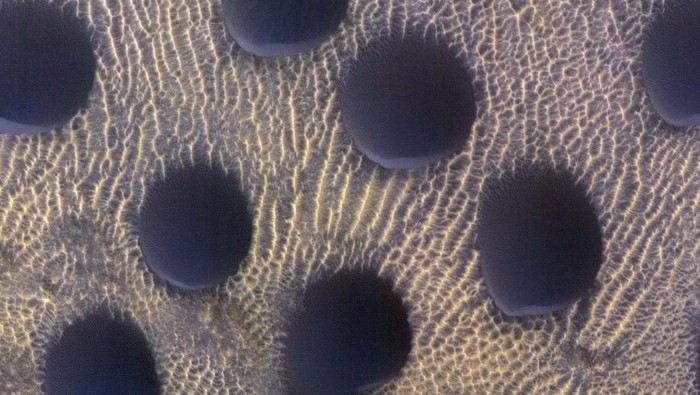 Potret Bukit Pasir di Permukaan Mars An undated image from NASA's Mars Reconnaissance Orbiter shows circular sand dunes on the surface of Mars, in this handout image obtained by Reuters on March 14, 2023. NASA/Jpl-Caltech/University of Arizona/Handout via REUTERS THIS IMAGE HAS BEEN SUPPLIED BY A THIRD PARTY. MANDATORY CREDIT. NO RESALES. NO ARCHIVES