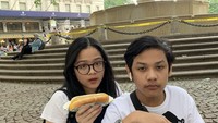 Tak hanya dessert, wanita 19 tahun ini juga terlihat menikmati jajanan hot dog. Ia dan adiknya sedang makan hot dog di taman. Foto: Instagram @cintakuya
