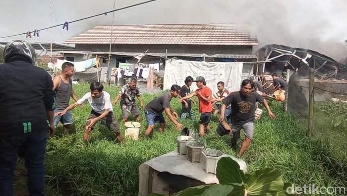 Warga kompak memadamkan kontrakan yang terbakar di Tasikmalaya, Selasa (14/3/2023).