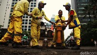 Petugas dari Dinas Bina Marga DKI Jakarta melakukan perbaikan jalan berlubang di Jl Karet Pasar Baru Timur, Jakarta, Rabu (15/3/2023).
