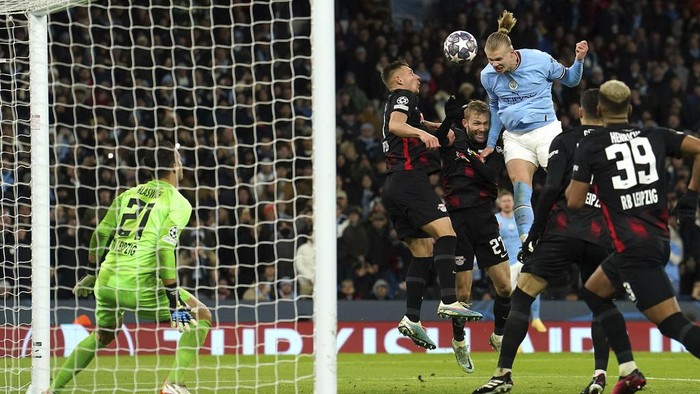 Manchester Citys Erling Haaland heads the ball which led to scoring his sides fifth goal of the game during the Champions League round of 16 second leg soccer match between Manchester City and RB Leipzig at the Etihad stadium in Manchester, England, Tuesday, March 14, 2023. (Nick Potts/PA via AP)