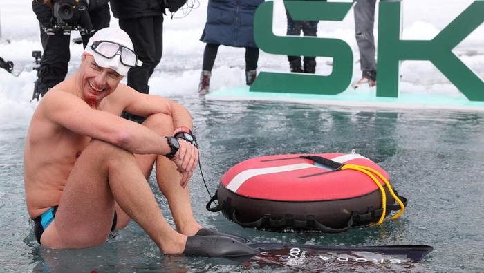 Aksi Penyelam Ceko Pecahkan Rekor Menyelami Danau Beku Swiss Czech freediver David Vencl comes out of the water after his successful attempt to dive 50 metres under the ice of Lake Sils in one breath and wearing only a swimsuit, in Sils near St. Moritz, Switzerland March 14, 2023. REUTERS/Denis Balibouse