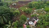 Rumah-rumah yang tertimbun longsor berada di antara tebing rel kereta api Bogor-Sukabumi dan aliran Sungai Cisadane. Pemukiman yang jadi lokasi longsor juga tidak bisa dilalui oleh kendaraan roda empat. (Aditya Aji/AFP/Getty Images)  