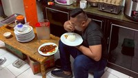 Momen makan sederhana lainnya terekam dalam foto ini. Ajudan Pribadi duduk di dapur sambil makan nasi hangat dan ikan. 