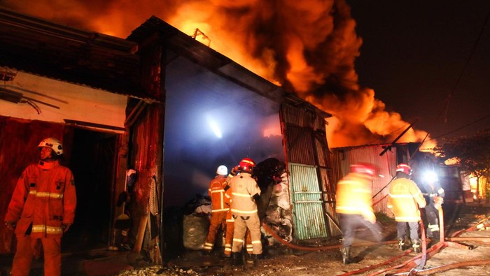 KEBAKARAN TEMPAT USAHA DI SURABAYA Petugas pemadam kebakaran menyemprotkan air untuk memadamkan api saat terjadi kebakaran di kawasan Nambangan, Surabaya, Jawa Timur, Rabu (15/3/2023). Petugas mengerahkan 24 unit kendaraan pemadam kebakaran untuk memadamkan api yang menghanguskan sejumlah tempat usaha pengepulan barang bekas dan mebel yang berdiri di atas lahan berukuran 50 meter kali 60 meter itu. ANTARA FOTO/Didik Suhartono/nym.