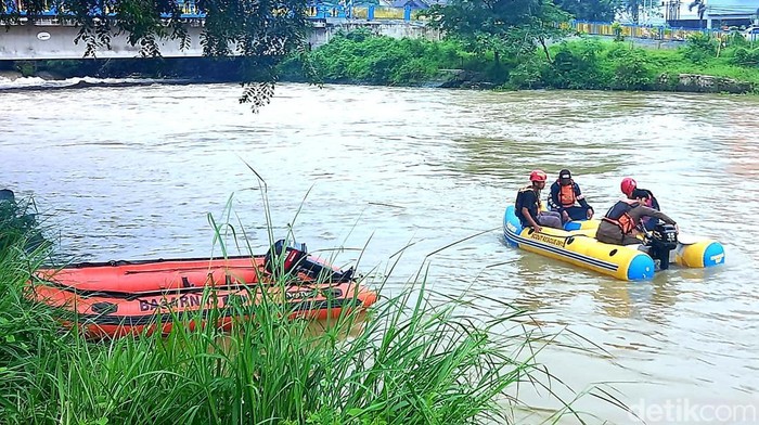 Petugas mencari keberadaan pemotor yang hanyut di irigasi di Karawang, Rabu (15/3/2023).