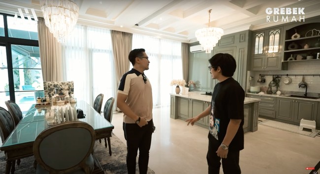 Di samping ruang keluarga terdapat ruang makan dan dapur. Dapurnya itu tampak cukup lengkap dan luas dengan kitchen set bernuansa hijau keabu-abuan. Foto: YouTube/AH
