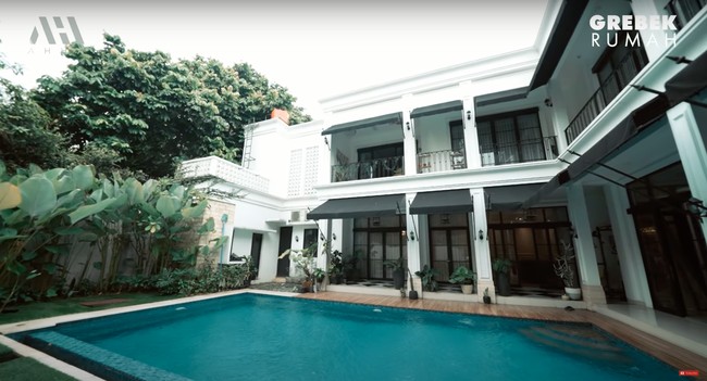Di bagian belakang rumah juga terdapat kolam renang yang cukup luas. Dikelilingi dengan pepohonan hijau, halaman belakang rumah Arie itu tampak asri dan sejuk. Foto: YouTube/AH