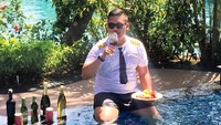 Akbar saat berada di kolam renang mewah yang di sampingnya ada minuman beralkohol. (Instagram/@ajudan_pribadi)