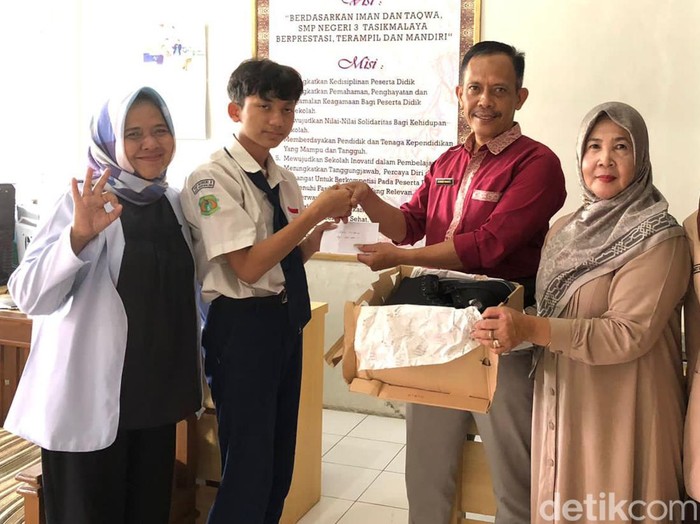 Zaky siswa SMPN 3 Kota Tasikmalaya saat menerima sepatu baru dan bantuan.