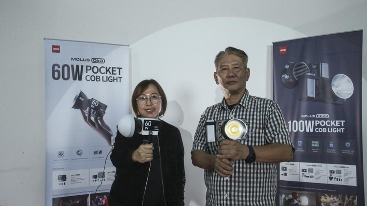 Fotografer Merapat, Lampu Portable Ini Cuma Segenggam Tangan General Manager PT Aneka Warna Indah & PT Aneka Warna Solusi Media Imelda Sanurita (kiri) dan Sales Manager PT Aneka Warna Solusi Media Henry Untung (kanan) saat mengenalkan Zhiyun Molus G60 dan Zhiyun Molus X100 di Jakarta, Kamis (16/3/2023). Produk lighting sekecil rubik ini memiliki kekuatan cahaya sebesar 60 watt dengan power supply listrik seperti biasa dan bisa juga menggunakan power supply type c.