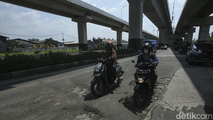 Hati-hati! Jalanan di Cakung Rusak Parah Pengendara melintas di jalan Raya Bekasi, Cakung, Jakarta Timur, Kamis (16/3/2023).