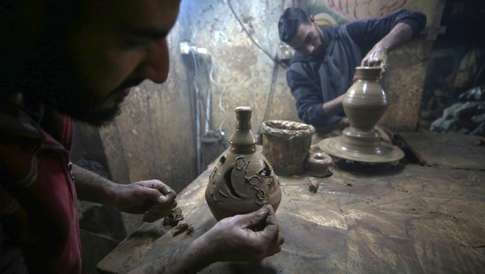 Intip Produksi Tembikar Ramadan Khas Palestina A Palestinian potter is putting the final touches to a clay lantern at his workshop in Gaza City, Palestine, on March 15, 2023, ahead of the start of the holy month of Ramadan during which Muslims fast from dusk to dawn and give alms to the poor. (Photo by Majdi Fathi/NurPhoto via Getty Images)