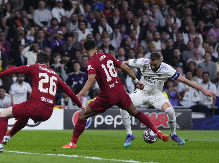 Real Madrid's Karim Benzema, right. Is challenged by Liverpool's Cody Gakpo, centre during the Champions League, round of 16 second leg soccer match between Real Madrid and Liverpool at the Santiago Bernabeu stadium in Wednesday, March 15, 2023. (AP Photo/Manu Fernandez)