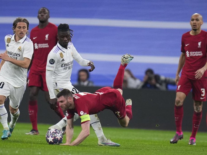 Liverpool's James Milner, centre, falls in front of Real Madrid's Eduardo Camavinga, 3rd from left during the Champions League, round of 16 second leg soccer match between Real Madrid and Liverpool at the Santiago Bernabeu stadium in Wednesday, March 15, 2023. (AP Photo/Manu Fernandez)