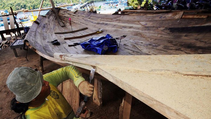 Melihat Proses Pembuatan Perahu Nelayan Pekerja menyelesaikan pembuatan kapal nelayan tradisional di Tambakrejo, Sumbermanjing Wetan, Malang, Jawa Timur, Rabu (15/3/2023). Pembuatan kapal nelayan berkapasitas 40 ton yang biasanya dikerjakan selama tiga bulan dengan biaya sekitar RP600 juta itu kini menghabiskan waktu enam bulan dengan biaya Rp800 juta per kapal yang disebabkan sulitnya mendapatkan bahan baku berupa kayu jati berkualitas. ANTARA FOTO/Irfan Sumanjaya/Zk/rwa.