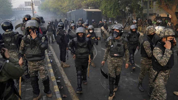Supporters of former Prime Minister Imran Khan chant anti government slogans as they gather outside Khans residence, in Lahore, Pakistan, Wednesday, March 15, 2023. Pakistani police have paused efforts to arrest former Prime Minister Imran Khan on graft charges after clashes continued for a second day outside his home in the eastern city of Lahore. (AP Photo/K.M. Chaudary)