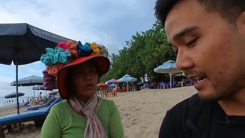 Seorang wisatawan dengan pedagang acung di Pantai Kuta. Foto: tangkapan layar/@wepergee