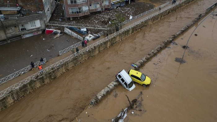 Penampakan Banjir Bandang Terjang Korban Gempa Turki People leave during floods after heavy rains in Sanliurfa, Turkey, Wednesday, March 15, 2023. Floods caused by torrential rains hit two provinces that were devastated by last month's earthquake, killing at least 10 people and increasing the misery for thousands who were left homeless, officials and media reports said Wednesday. At least five other people were reported missing. (Hakan Akgun/DIA via AP)